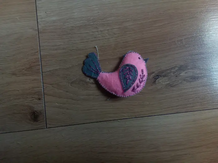 Ručne vyšívaný rúžový vtáčik.